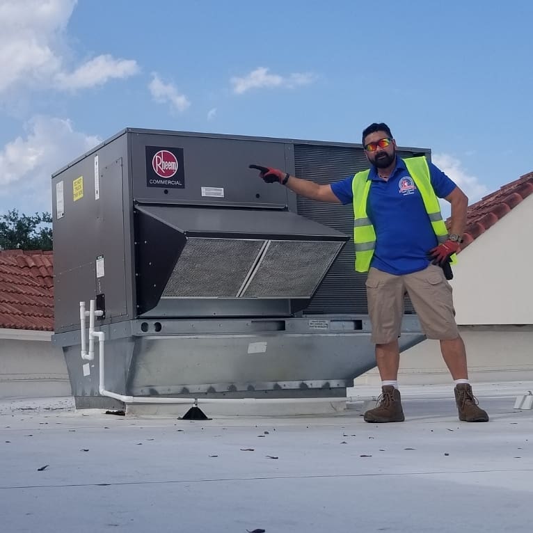 Cool & Heat technician servicing commercial AC unit